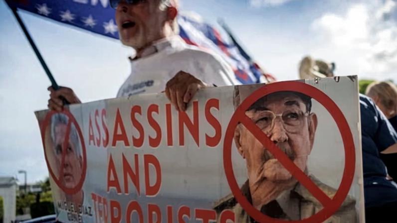 A Cuban in exile holds up a sign in protest of Cuba’s leaders in Miami on Wednesday.