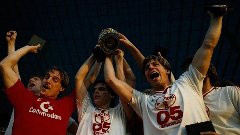 Bayer Uerdingen players celebrate with the DFB Cup in the stands, from left to right: Horst Feilzer, Matthias Herget and Norbert Brinkmann.