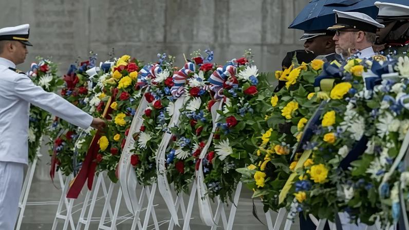 Men in uniform near floral wreaths
