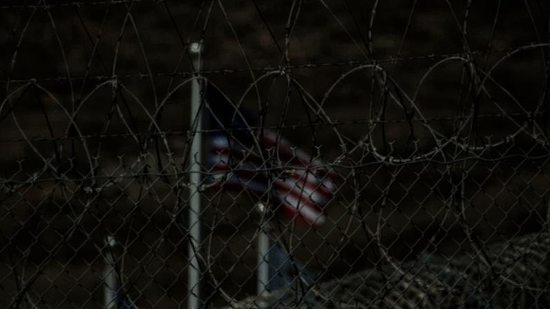 An American flag through barbed wire.