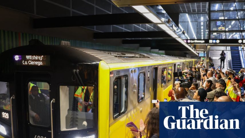 Yellow train, subway station full of people wearing purple