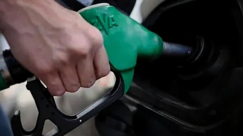 Close-up image of a green petrol pump refilling a car