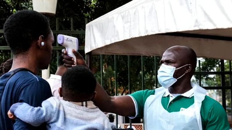 A health official uses a thermometer to screen people in front of Kibuli Muslim Hospital in Kampala, Uganda, 16 May, 2026.