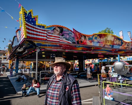 A man in a cowboy hat in front of a US-themed dodgems ride in Landstuhl