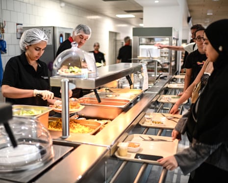 Staff serve university students at a food counter