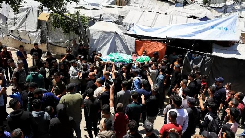 Pessoas carregam um corpo identificado por pessoas de luto como o comandante da ala militar do Hamas, Izz al-Din al-Haddad, que foi morto em um ataque israelense na sexta-feira, durante um funeral, na Cidade de Gaza, em 16 de maio de 2026. REUTERS/Dawoud Abu Alkas
