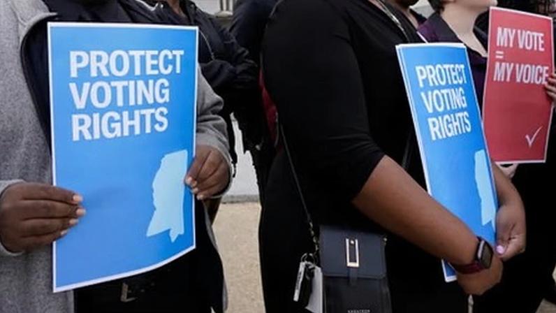 Members of voting rights groups hold signs calling for protection of voting rights in Jackson, Mississippi, on 7 December 2023.