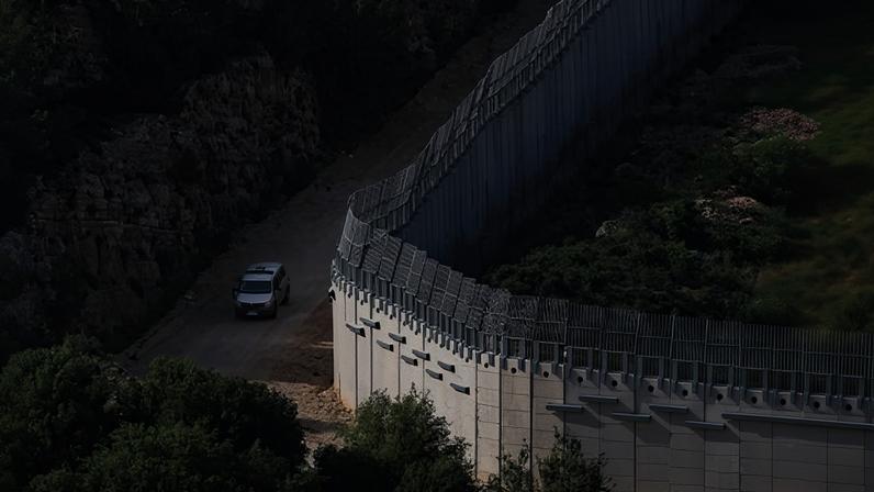 An Israeli military vehicle drives beside the Israeli‑Lebanese border in northern Israel.