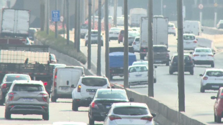 Tráfego intenso de carros e caminhões em rodovia urbana