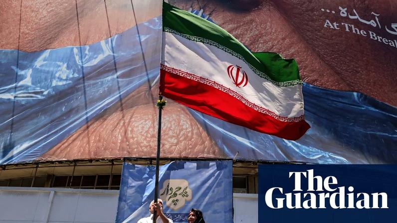 A man raises an Iranian flag in Tehran’s Valiasr Square