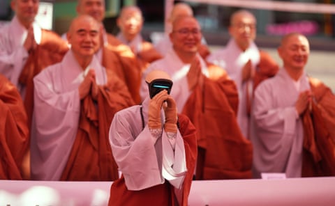 A humanoid robot prays with Buddhist monks at a temple in Seoul, South Korea.