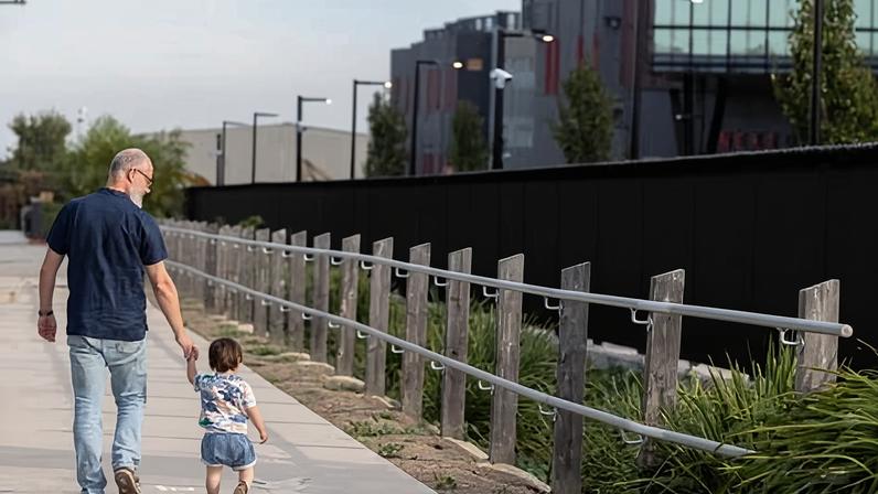Melbourne resident Sean Brown with his son walking past the NextDC datacentre – ‘Australia’s largest hyperscale AI factory’ – in West Footscray.