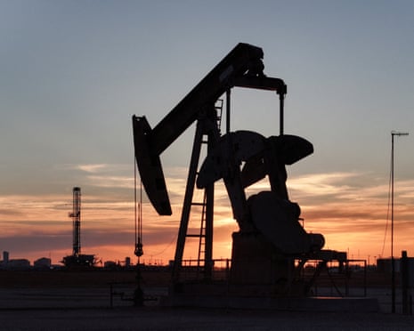 A pump jack and drilling rig south of Midland, Texas.