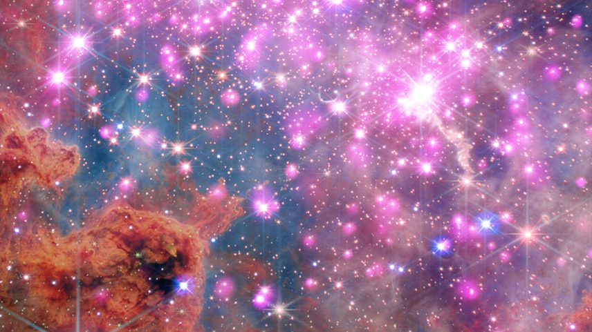 Scores of gleaming stars ringed in neon pink stretch across the frame, highlighting a cluster where stars are between one and three million years old.