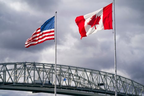 The US and Canadian flags flutter next to the Blue Water Bridge border crossing in Point Edward, Ontario, on 24 October 2025.