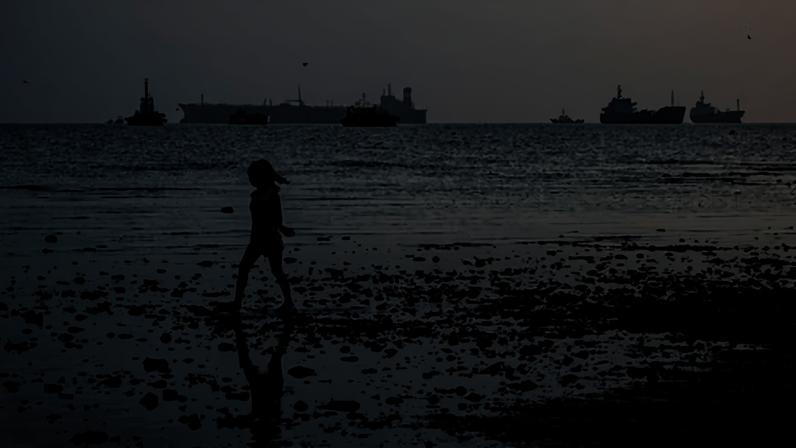 A child plays on the shore as the Panamanian-flagged Tiger Wings, carrying crude oil from Russia, is seen moored off the Philippines in April.