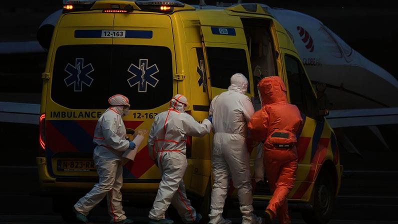 Paramédicos acompanham um paciente, o segundo à direita, evacuado do navio de cruzeiro MV Hondius com suspeita de infecção por hantavírus, até uma ambulância após ser levado de avião para o aeroporto de Schiphol, em Amsterdã, Holanda