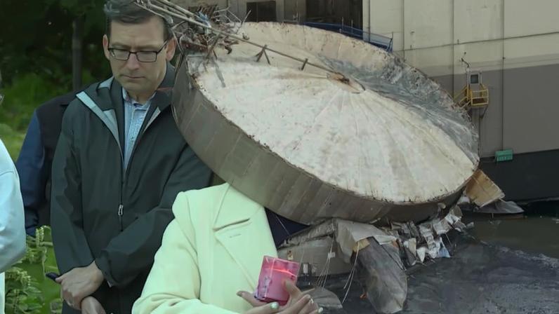 Left, the erupted tank. Right, a woman and mourners look on.