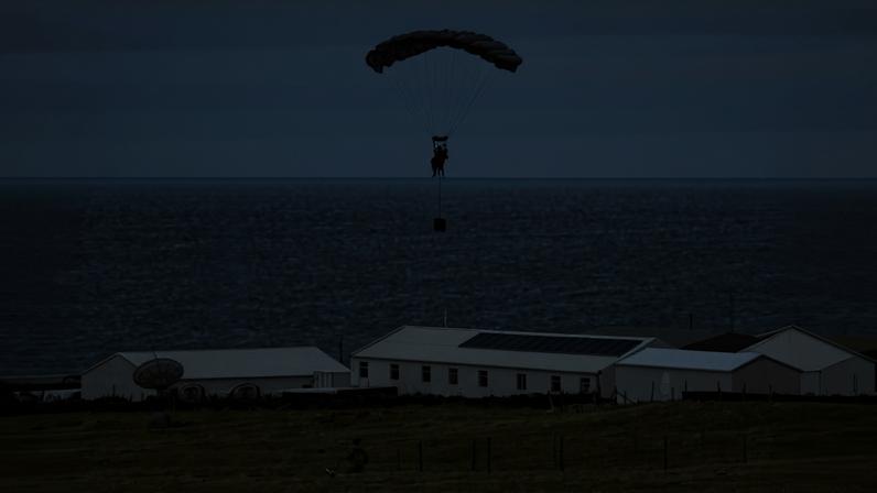 Captain George Lacey (left), and parachutist landing on the island (right)