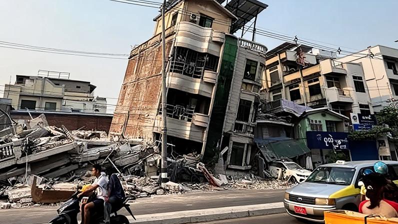 Reuters Commuters drive past a building that collapsed in the aftermath of a strong earthquake in Mandalay, Myanmar. March 30, 2025.