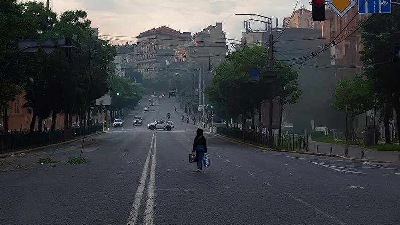 Uma mulher caminha por uma rua coberta de destroços após um ataque noturno russo com mísseis e drones, em meio à ofensiva da Rússia contra a Ucrânia, em Kiev, Ucrânia, em 24 de maio de 2026.