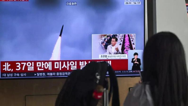 Noticiário na TV sul-coreana exibe imagens de arquivo de um teste de míssil norte-coreano, em uma estação ferroviária em Seul, em 26 de maio de 2026.