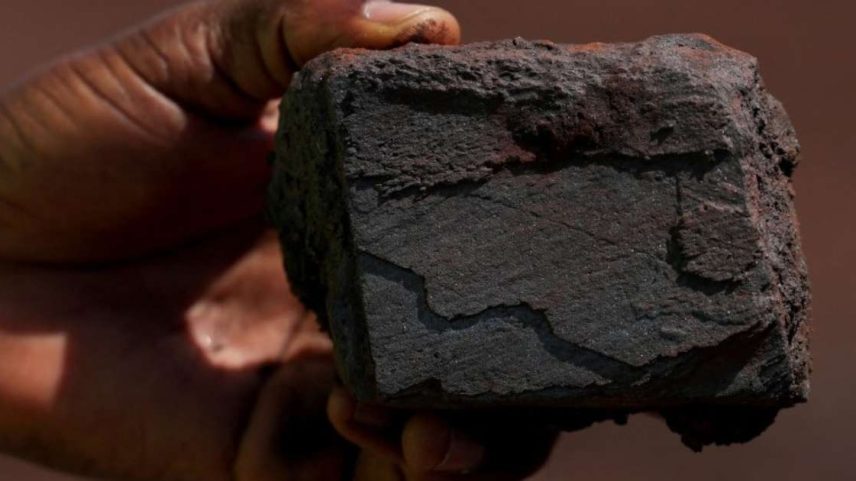 Um homem segura um pedaço de minério de ferro 5 de novembro de 2025 REUTERS/Luc Gnago