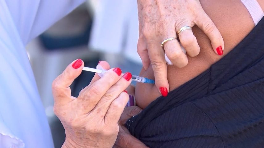 Aplicação de vacina no braço de uma pessoa por profissional de saúde