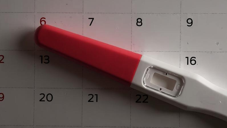 Teste de gravidez em cima de um calendário