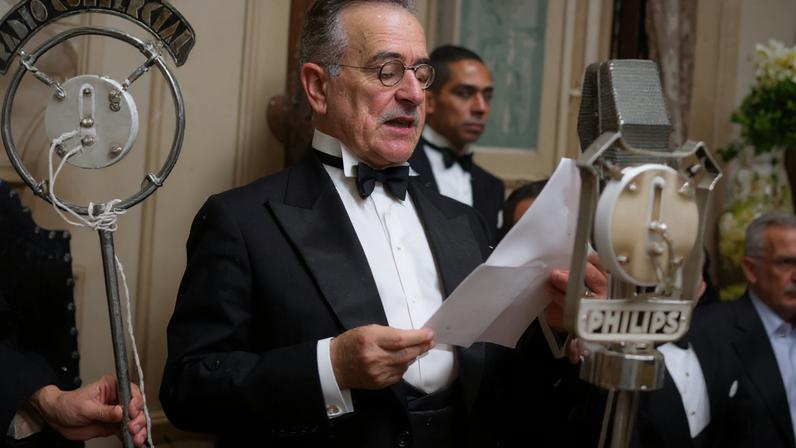 Getúlio Vargas lendo um documento enquanto fala ao microfone
