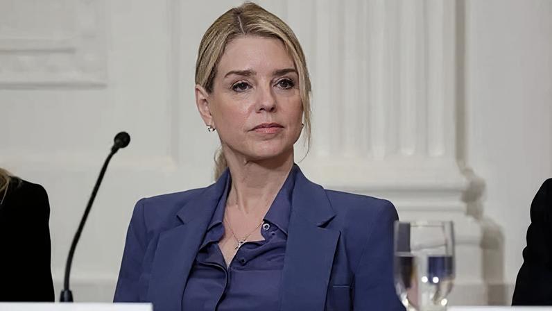 Getty Images Former US Attorney General Pam Bondi sits at a table behind a tabletop microphone as she listens to US President Donald Trump speak during a lunch with the Trump Kennedy Center Board Members on 16 March 2026.