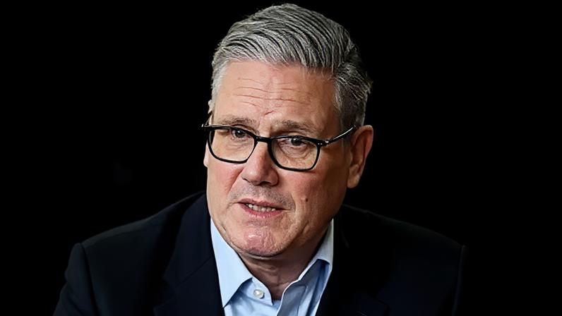 Sir Keir Starmer, UK prime minister, wearing glasses, a dark suit jacket and a blue shirt.