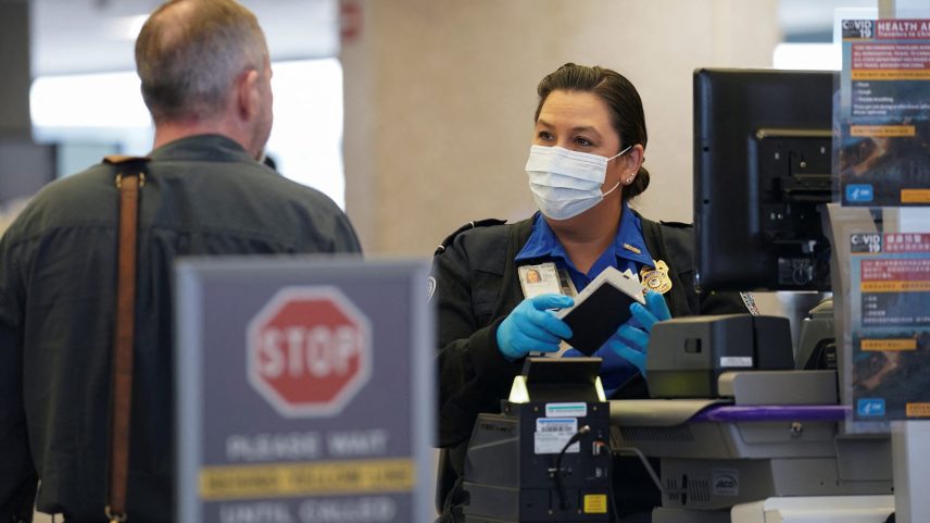 A TSA officer wearing a face mask clears a departing passenger at Dulles International Airport in Dulles, Virginia, on March 12, 2020.