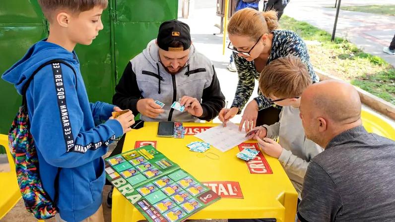 Pessoas manuseando figurinhas do álbum da Copa