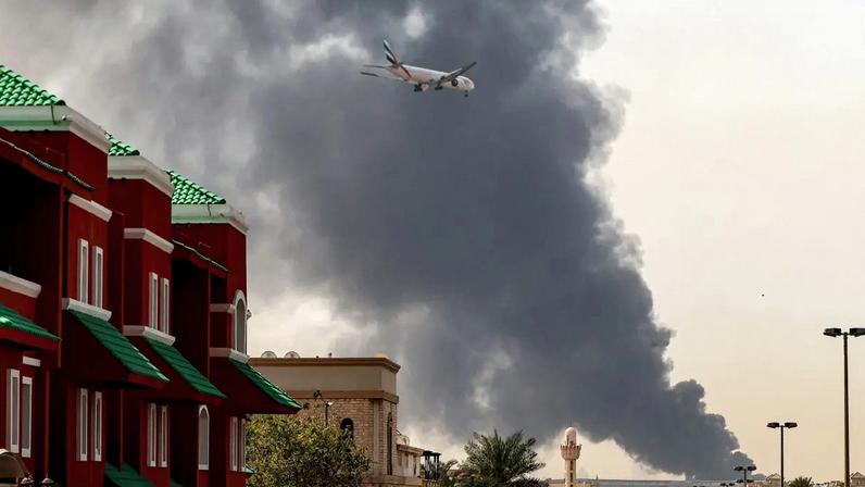 Uma aeronave da Emirates se prepara para pousar enquanto uma coluna de fumaça sobe de um incêndio próximo ao Aeroporto Internacional de Dubai, nos Emirados Árabes Unidos, em meio à guerra EUA-Israel x Irã. 16/03/2026 - (AFP/AFP)