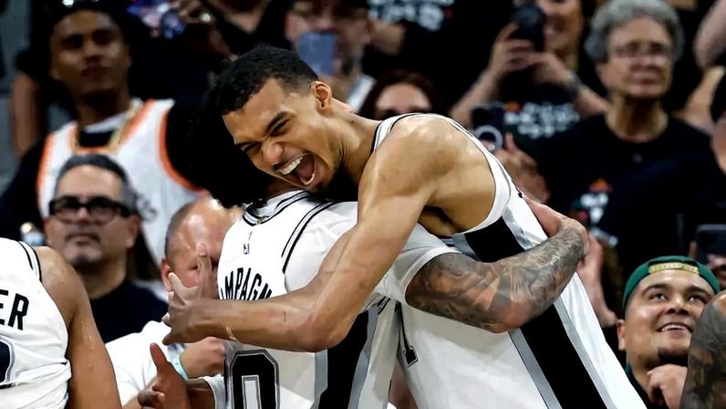Victor Wembanyama e Julian Champagnie, do Spurs, se abraçam após vitória sobre o Trail Blazers no jogo cinco da primeira rodada dos playoffs da Conferência Oeste (Foto: Ronald cortes/Getty images/Afp)