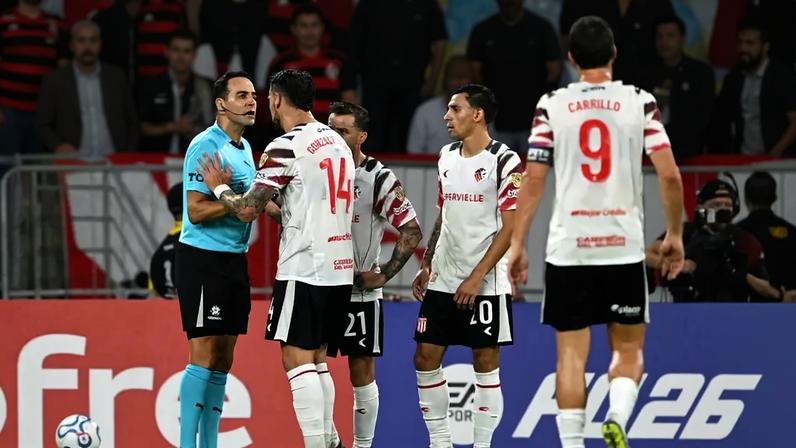 Jogadores do Estudiantes cobrando o árbitro após a marcação do pênalti contra o Flamengo