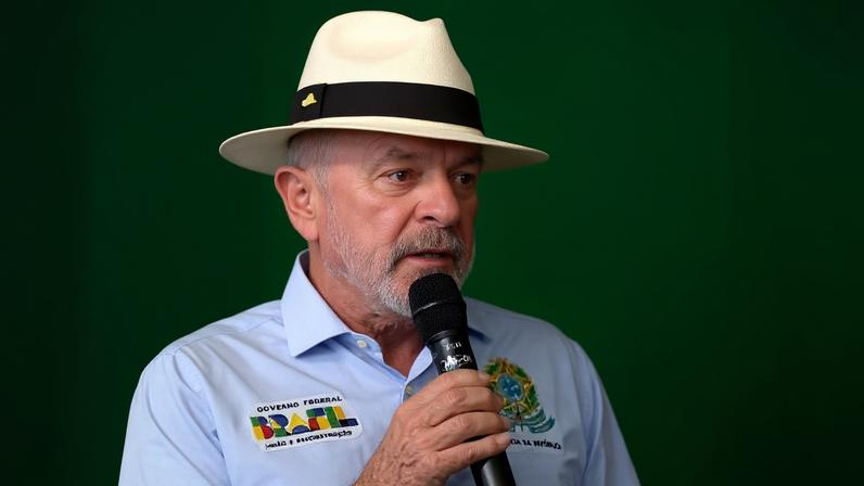 O presidente Lula discursa de chapéu Panamá e camisa azul.
