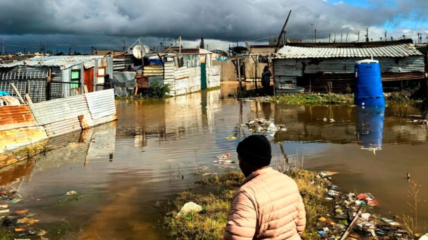A woman walks on a waterlogged pathway of the informal settlement in Khayelitsha, on the outkirks of Cape Town, South Africa, Tuesday, May 12, 2026. (AP Photo/Bheki Radebe)