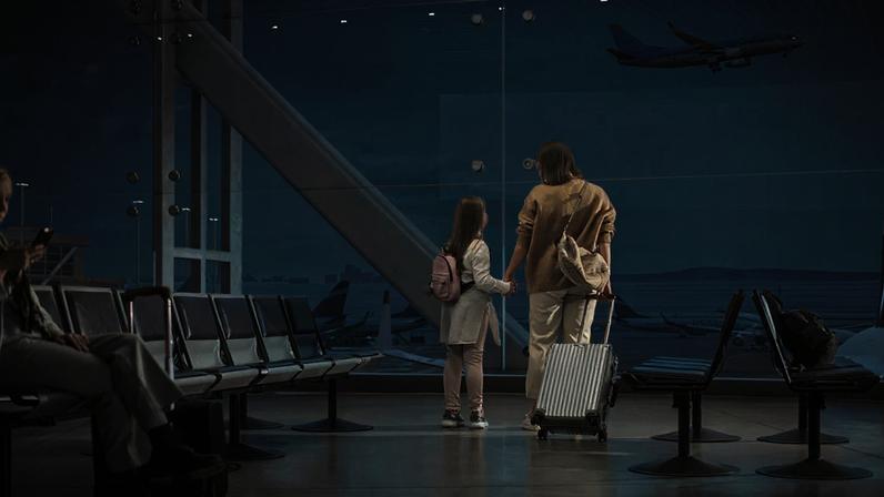 Área de embarque de aeroporto; mãe e filha observam avião decolando; embarque; viagem; turismo; avião