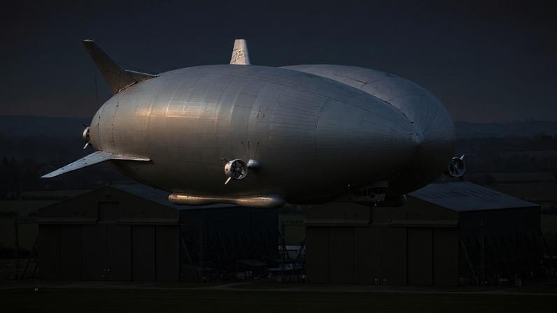 Airlander 10 em hangar com composição técnica sobre aviação de baixo carbono