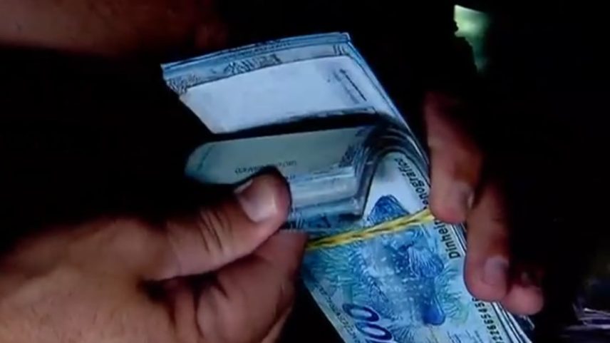 Pessoa contando notas de R$ 100