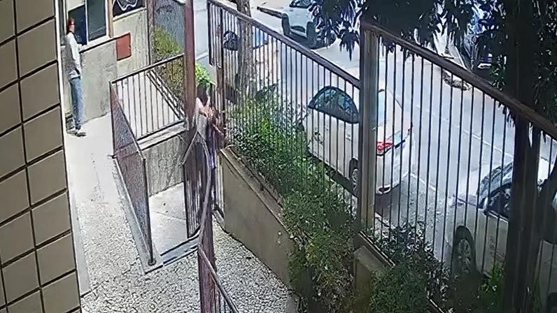 Autor tentando assaltar a vítima no portão do prédio