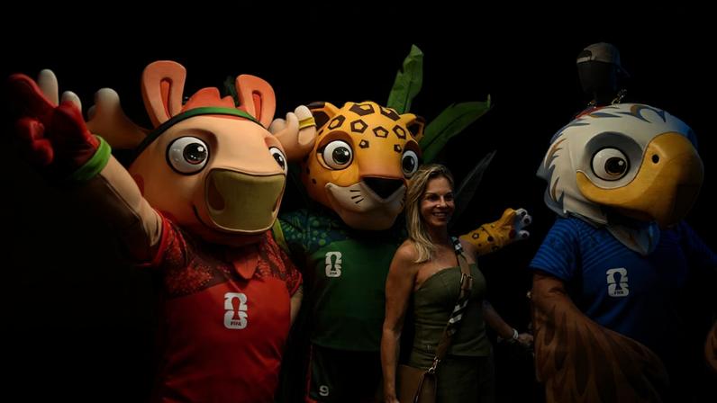 Mascotes da Copa do Mundo posam com fã.