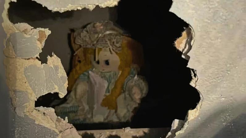 Boneca estava escondida em um buraco na parede coberto com gesso