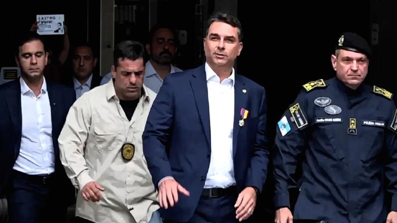 15/05/2026 - Flávio Bolsonaro visita batalhão da PM no Rio de Janeiro para falar sobre segurança pública, mas não consegue fugir das perguntas em torno da polêmica envolvendo a cinebiografia do pai, o ex-presidente Jair Bolsonaro (Viory/Reprodução)