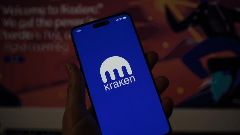Celular com o logo da corretora de criptomoedas Kraken na tela