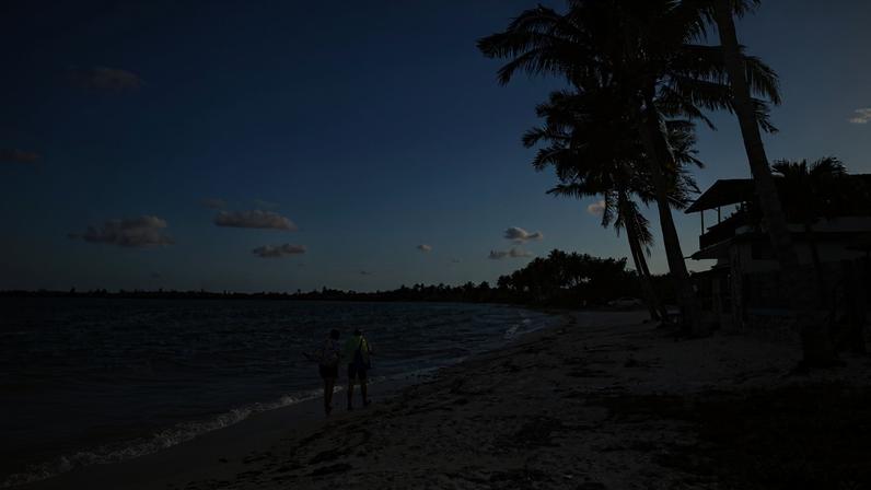 Pessoas caminham perto de casas de aluguel enquanto os principais destinos turísticos de Cuba permanecem desertos em meio à escassez de energia, em Playa Larga, Ciénaga de Zapata, Cuba - 07/04/2026 (Foto: REUTERS/Norlys Perez)