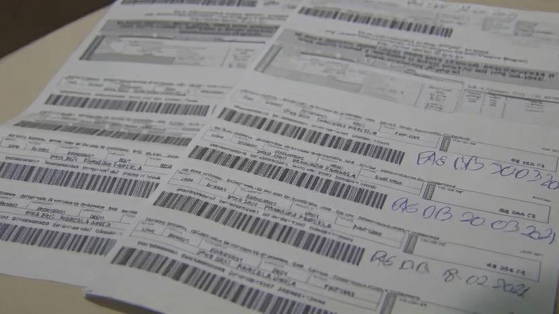 Folhas de contas e boletos bancários com códigos de barras sobre uma mesa