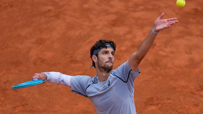 Lorenzo Musetti saca a bola durante sua partida contra Casper Ruud no Roma Open.